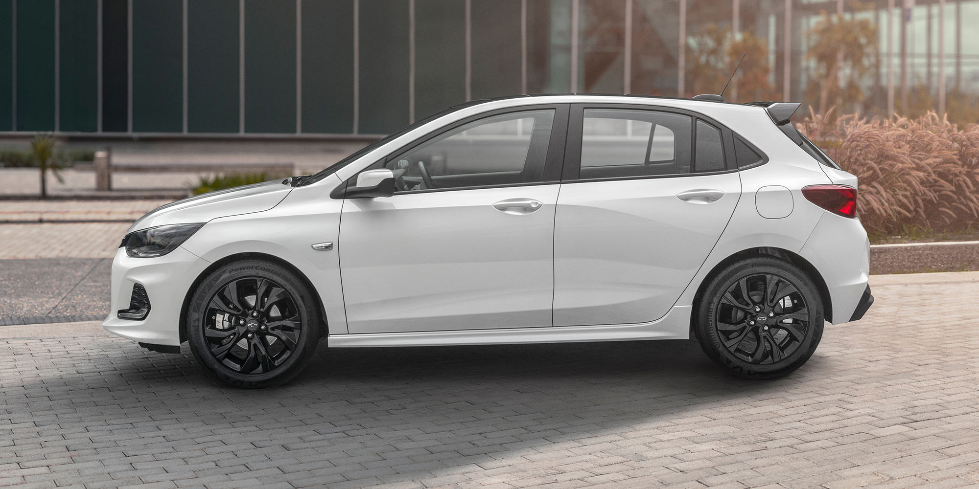 Chevrolet Onix RS estacionado en frente de un edificio.