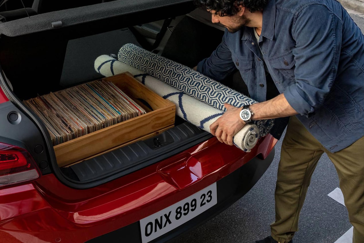 Hombre cargando objetos en el maletero del Onix.
