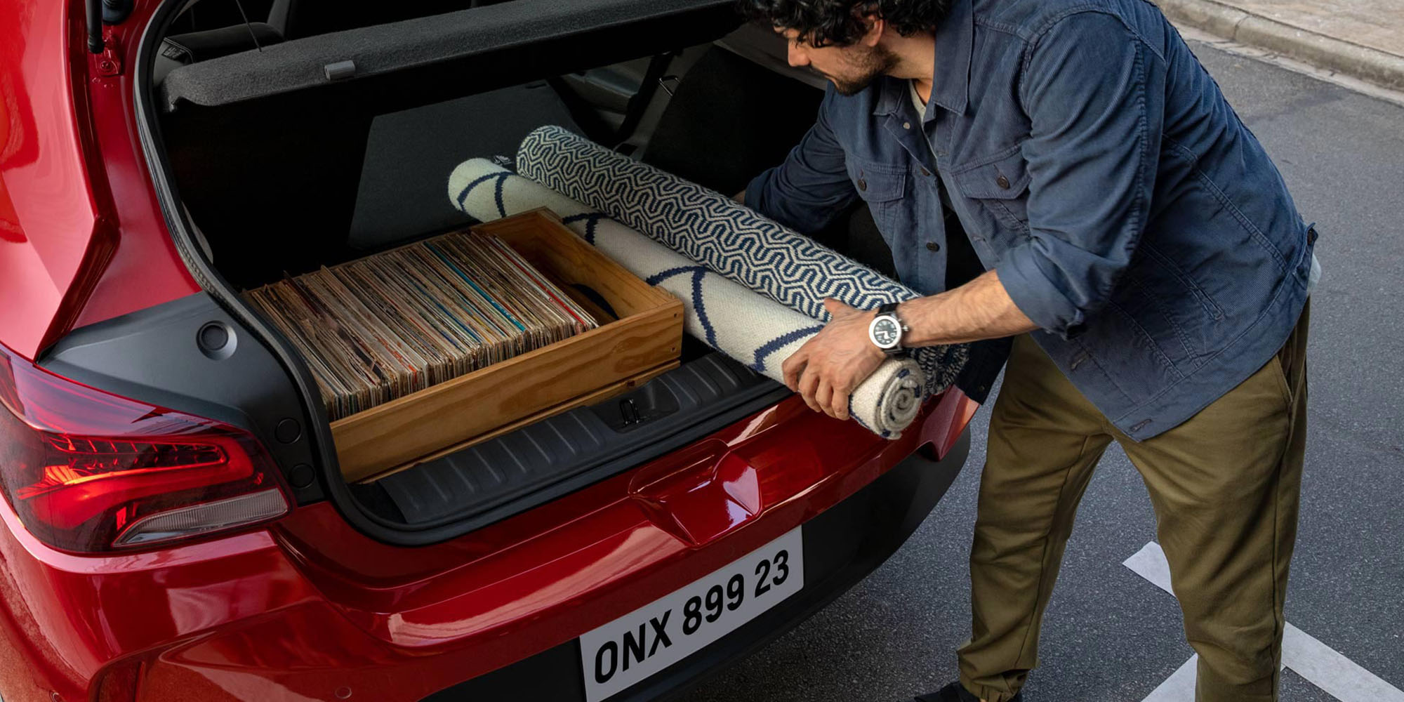 Hombre cargando objetos en el maletero del Onix.