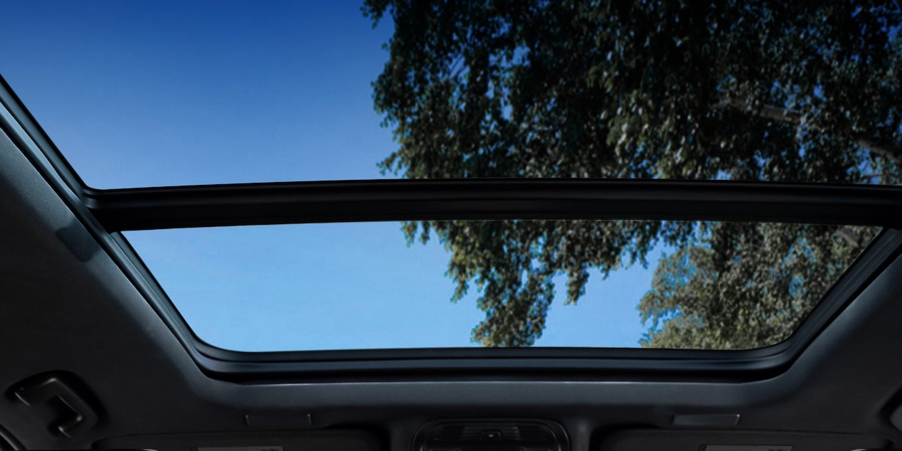 Interior de una Chevrolet Suburban Z71 con asientos delanteros tipo butaca y traseros tipo banca en EcoCuero negro, con insertos perforados, costuras y emblemas únicos.