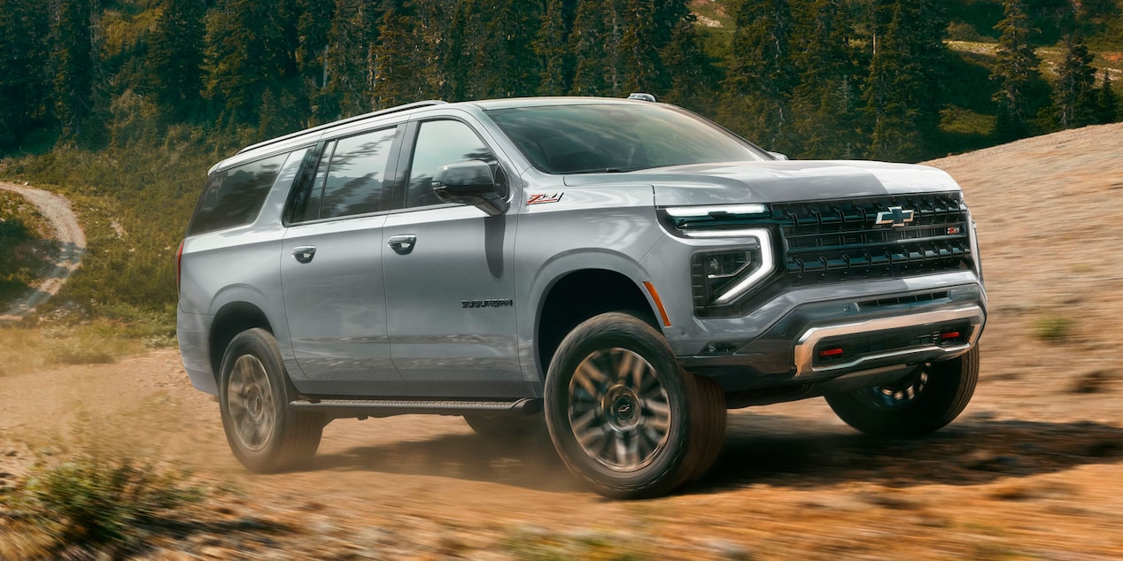 Vista lateral de la Chevrolet Suburban Z71 recorriendo un camino de tierra en la montaña.