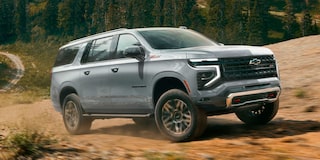 Vista lateral de la Chevrolet Suburban Z71 recorriendo un camino de tierra en la montaña.