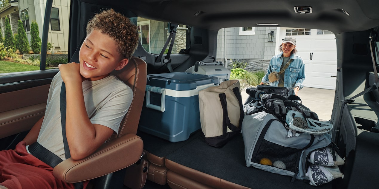 Niño disfrutando de un viaje en la Chevrolet Suburban Z71 mientras se destaca el amplio espacio de carga del maletero.