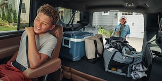 Niño disfrutando de un viaje en la Chevrolet Suburban Z71 mientras se destaca el amplio espacio de carga del maletero.