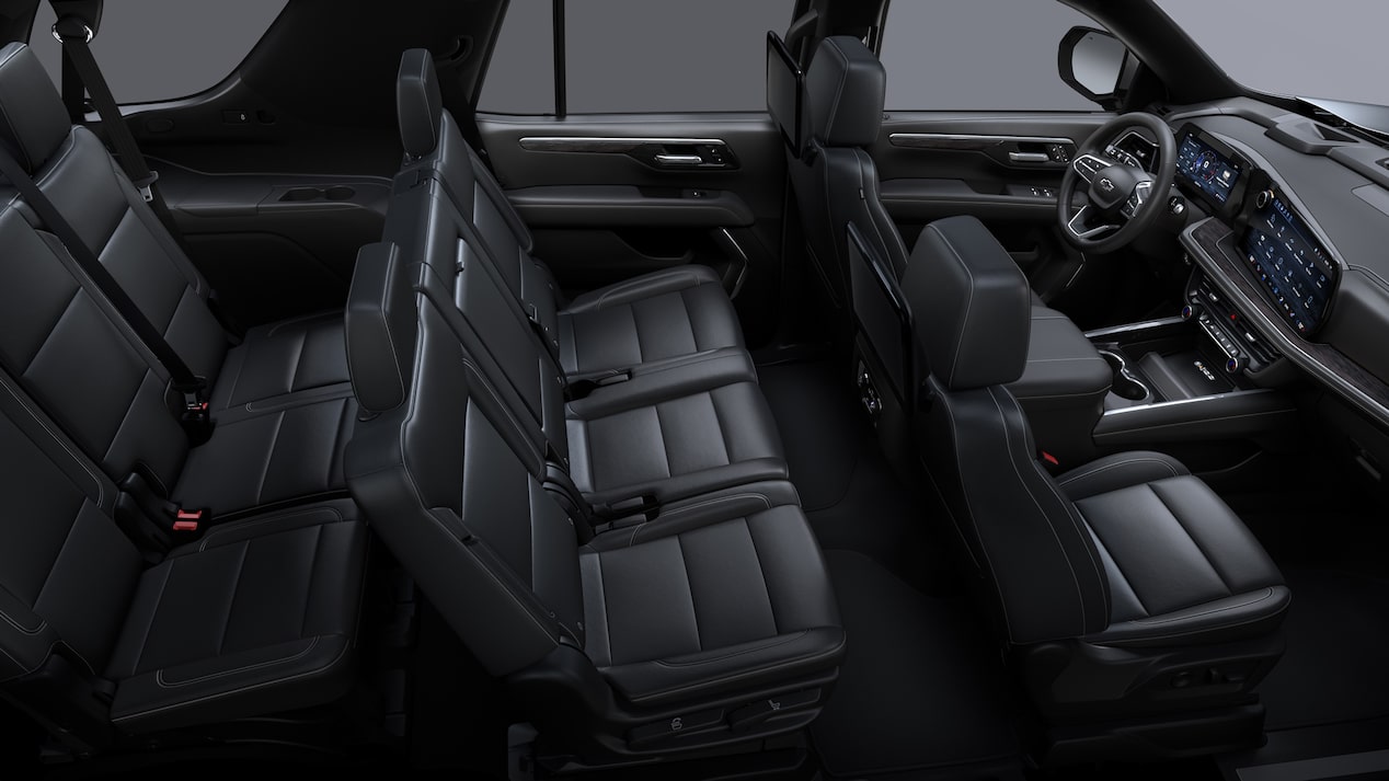 Vista interior de una Chevrolet Suburban Z71 con asientos delanteros tipo butaca y asientos traseros tipo banca en EcoCuero negro con detalles perforados y costuras distintivas.