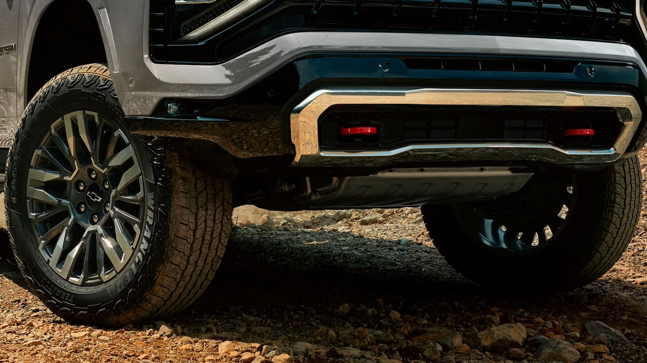 Detalle de la parte frontal y ruedas de la Chevrolet Suburban Z71 sobre terreno rocoso, destacando su sistema de tracción configurable.
