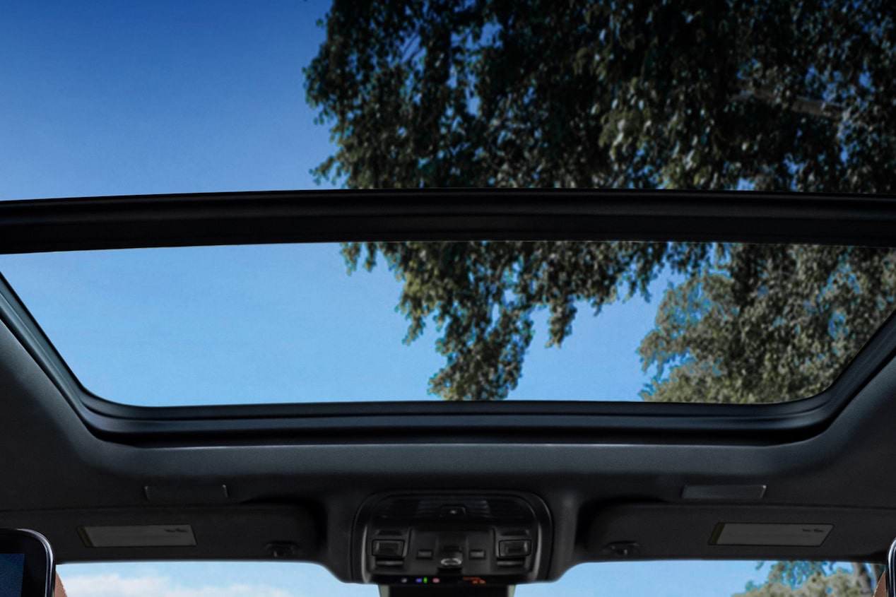  "Sunroof panorámico eléctrico de la Chevrolet Suburban Z71 con vista al cielo y los árboles desde el interior del vehículo. "