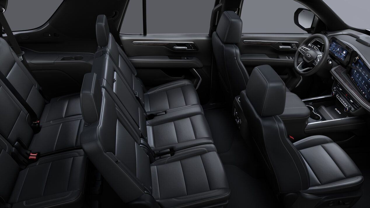Vista interior de una Chevrolet Suburban Z71 con asientos delanteros tipo butaca y asientos traseros tipo banca en EcoCuero negro con detalles perforados y costuras distintivas.