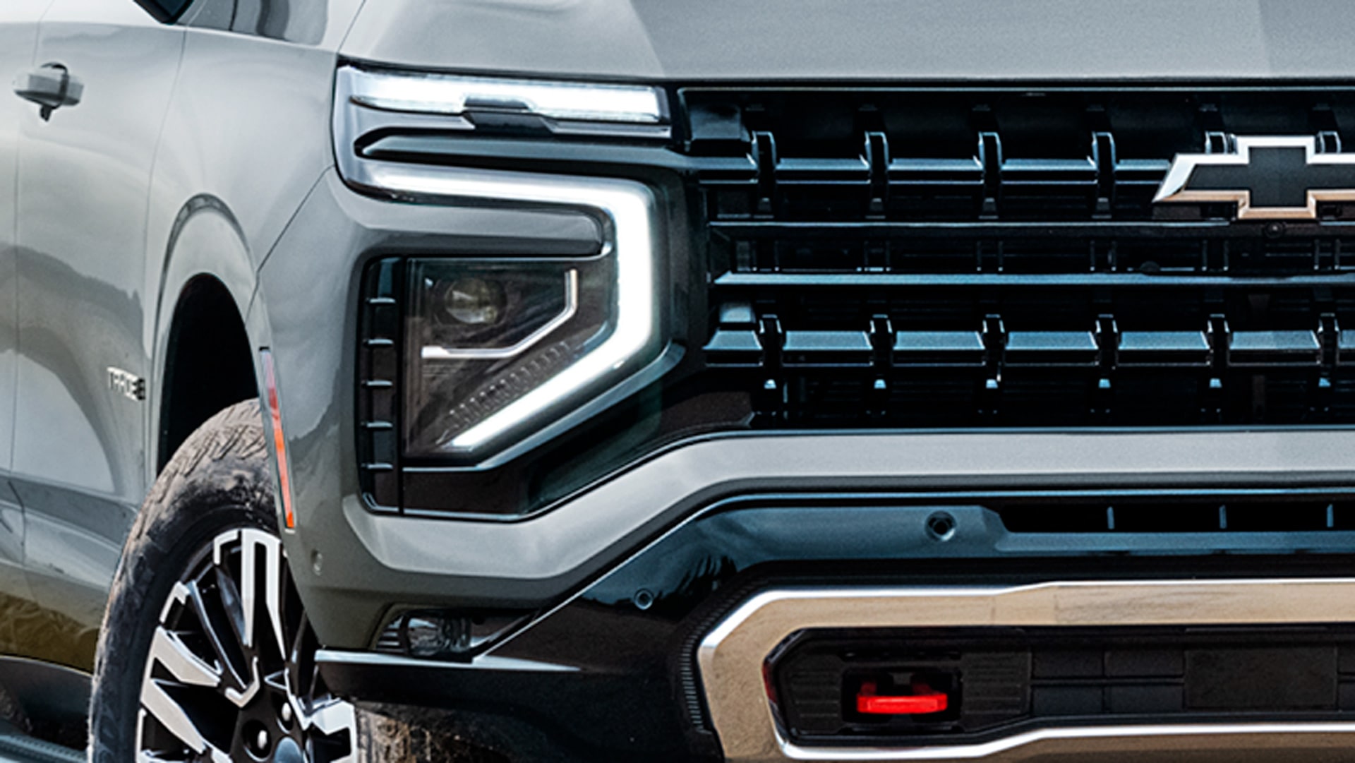 Vista cercana de la parrilla frontal de la Chevrolet Tahoe con los focos LED encendidos.