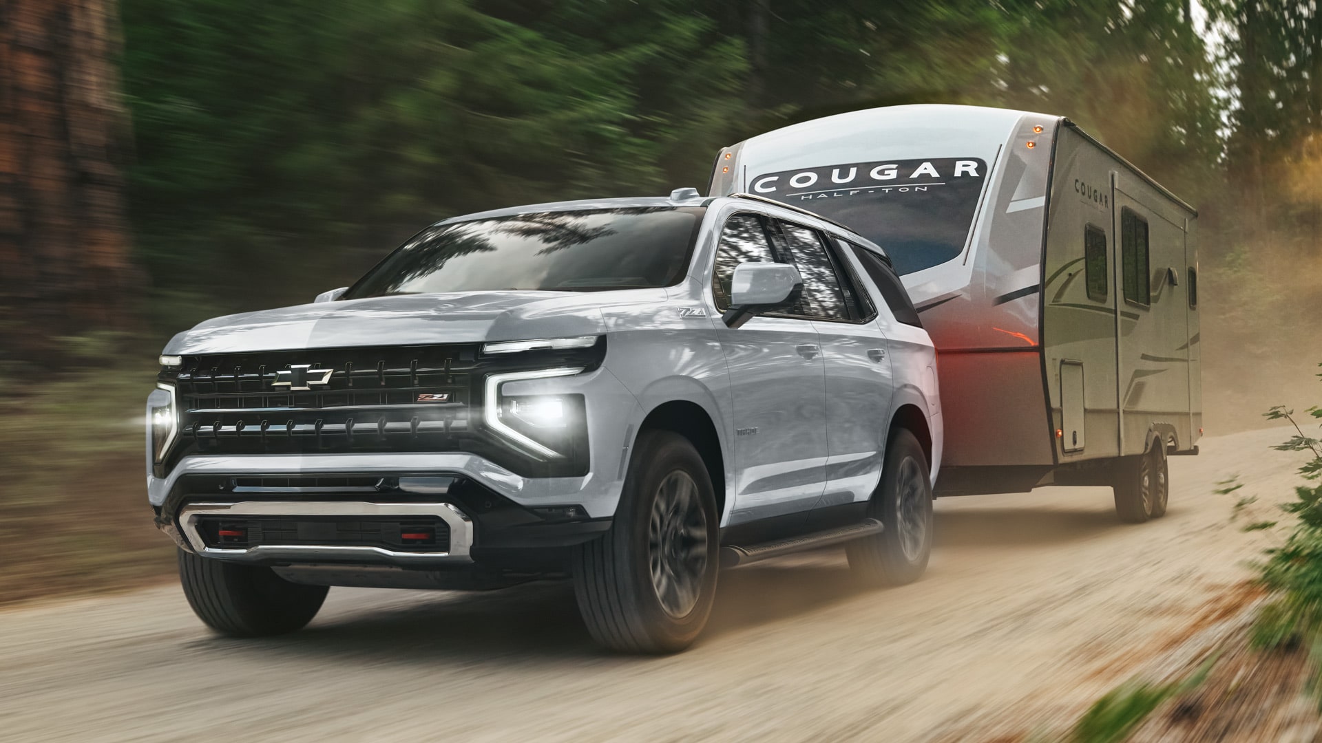 Chevrolet Tahoe transportando un tráiler por un camino de tierra.
