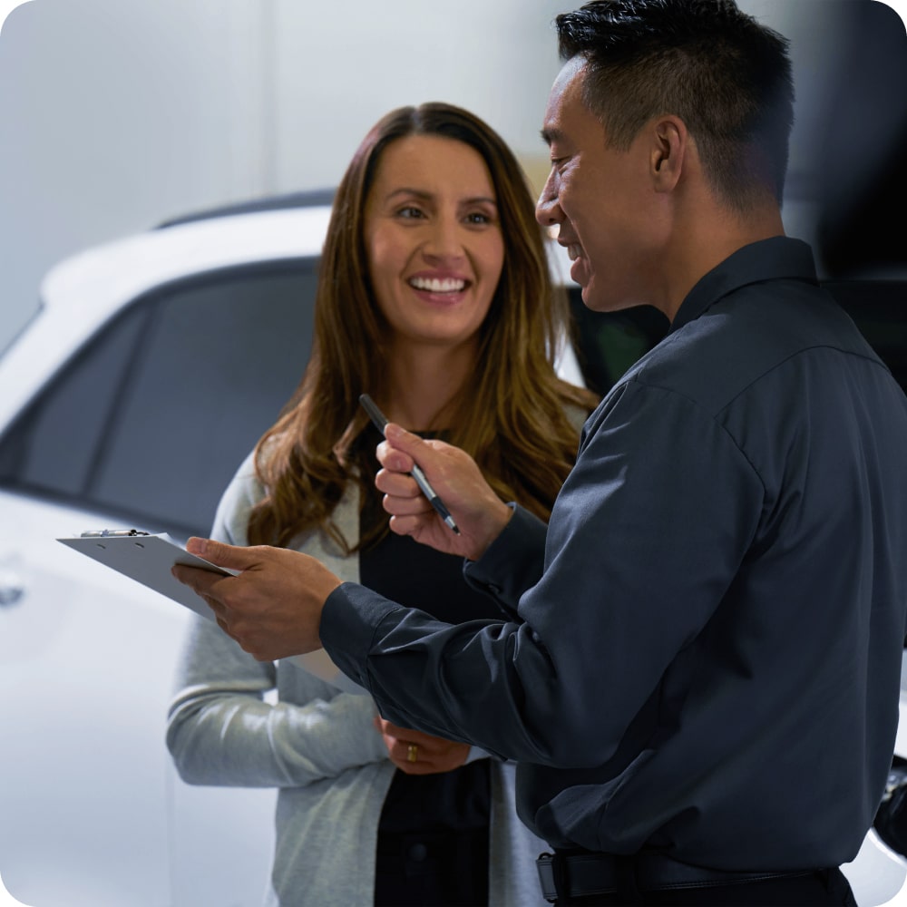 Asesor de servicio atendiendo a una clienta en un concesionario Chevrolet.