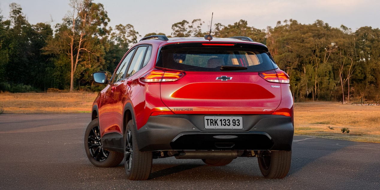 Vista trasera dela Chevrolet Tracker RS estacionada en zona descampada.