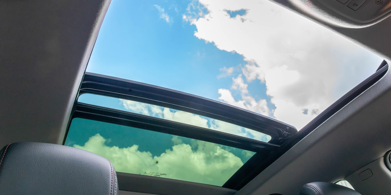 Vista interior destacando el techo solar panóramico de la Chevrolet Tracker RS, con vista al cielo.