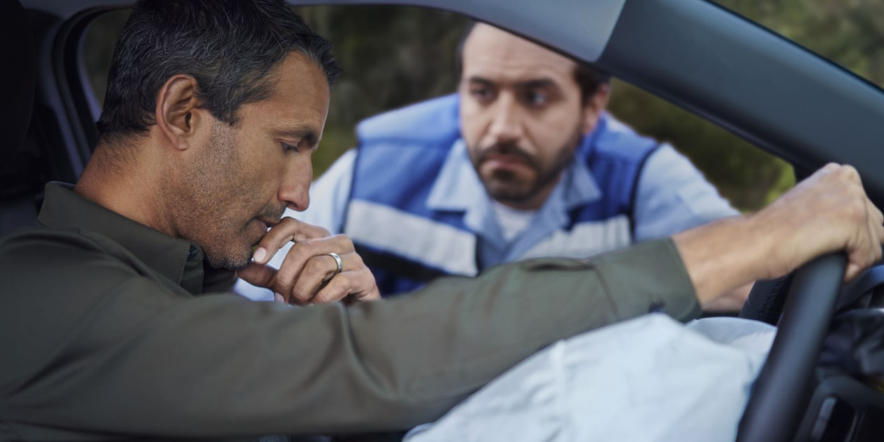 Conductor de Chevrolet recibiendo asistencia tras accidente con airbag activado y enfoque en seguridad