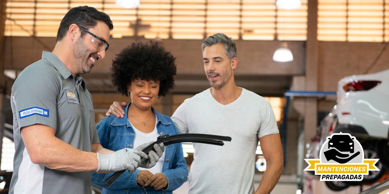 Especialista mostrando unos repuestos a unos clientes.