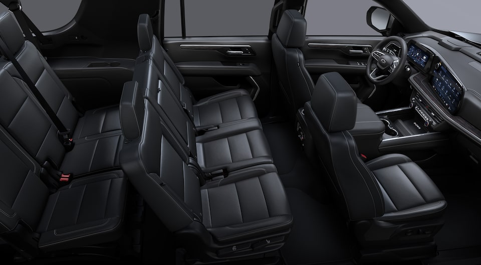 Interior de la Chevrolet Suburban Z71 2025 con vista a las tres filas de asientos en cuero negro y pantalla digital de alta tecnología