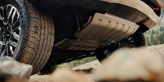 Protección inferior de la Chevrolet Suburban 2025 con detalles del sistema de suspensión y blindaje para conducción off-road sobre terrenos exigentes