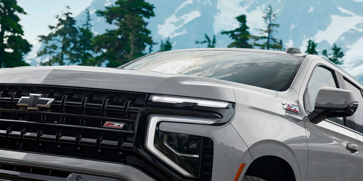 Chevrolet Suburban Z71 2025 vista frontal con detalle de parrilla negra, insignia Z71 y faros LED en entorno montañoso