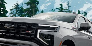 Chevrolet Suburban Z71 2025 vista frontal con detalle de parrilla negra, insignia Z71 y faros LED en entorno montañoso