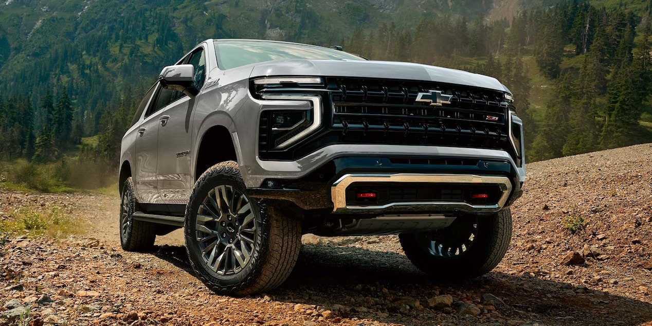 Vista frontal baja de la Chevrolet Suburban Z71 2025 recorriendo camino off-road con suspensión elevada y diseño robusto