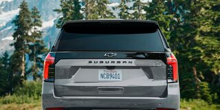 Vista trasera de la Chevrolet Suburban Z71 2025 mostrando el logo central de Chevrolet y diseño de luces verticales en entorno natural