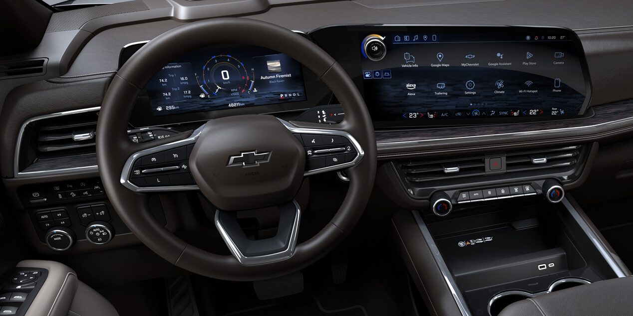 Interior de la Chevrolet Suburban mostrando el volante multifunción y doble pantalla digital de alta tecnología