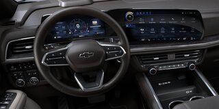 Interior de la Chevrolet Suburban mostrando el volante multifunción y doble pantalla digital de alta tecnología