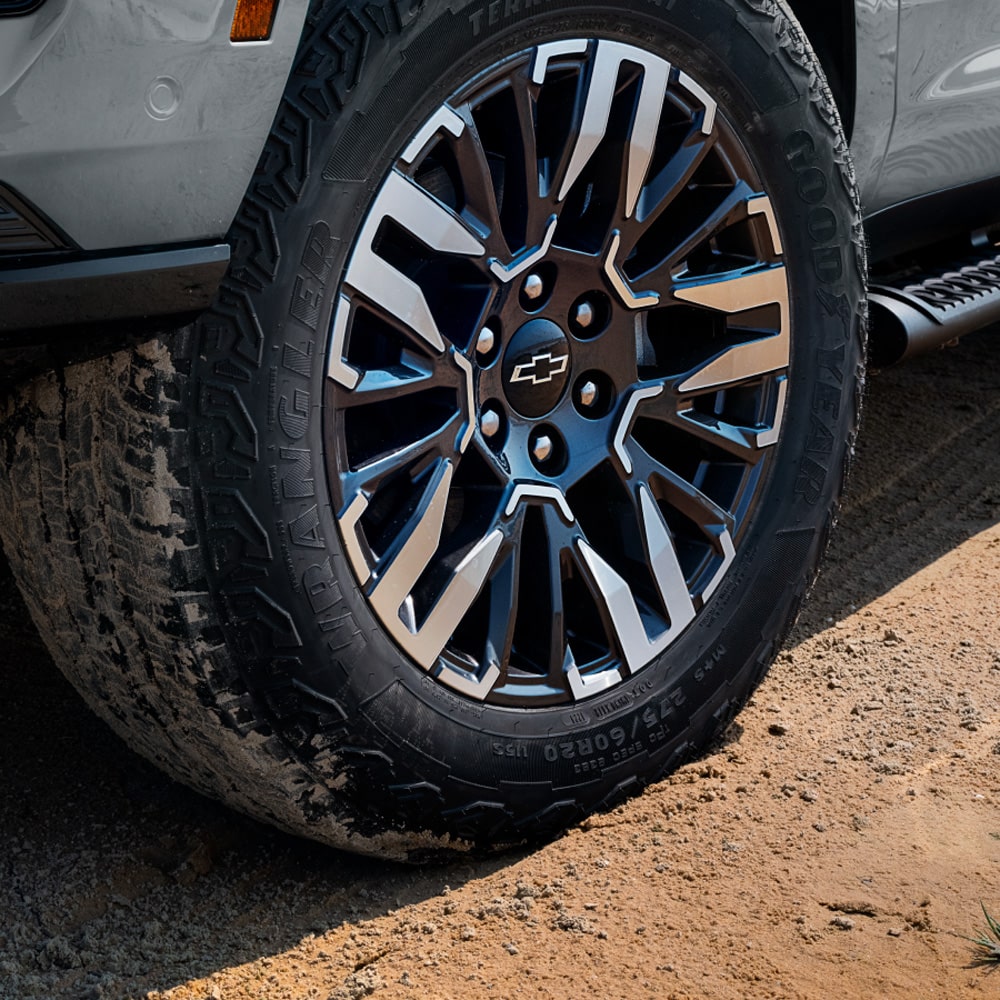 Detalle del rin y llanta todoterreno de la Chevrolet Tahoe 2025 Z71 sobre terreno de tierra