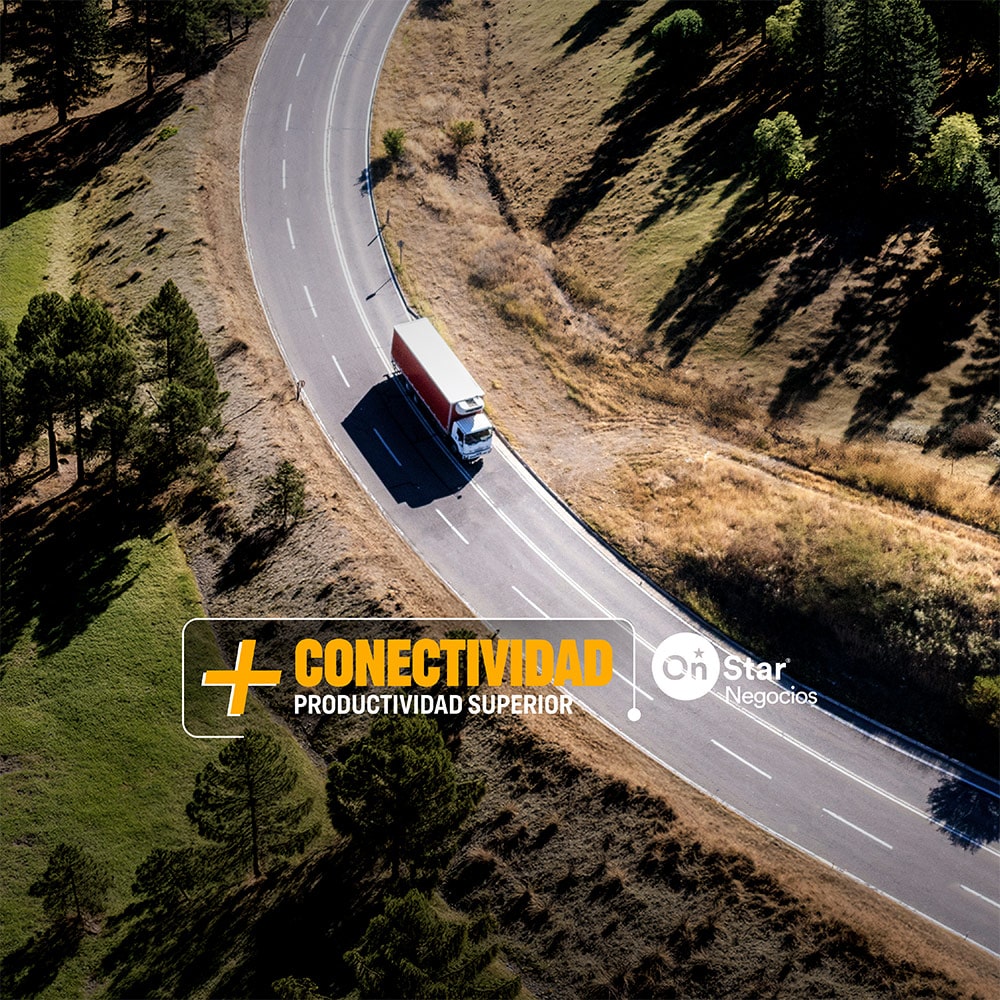Vista aérea de un camión Chevrolet NKR Euro VI circulando por una ruta, con el siguiente texto por encima: Más conectividad. Productividad superior. OnStar Negocios.