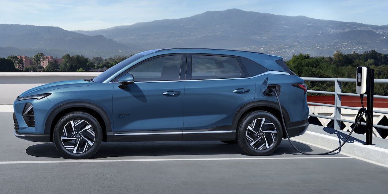 Vista lateral de la Chevrolet Captiva PHEV estacionada y cargándose eléctricamente.
