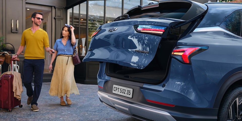 Una pareja acercándose a la Chevrolet Captiva PHEV para guardar sus pertenencias en el maletero.