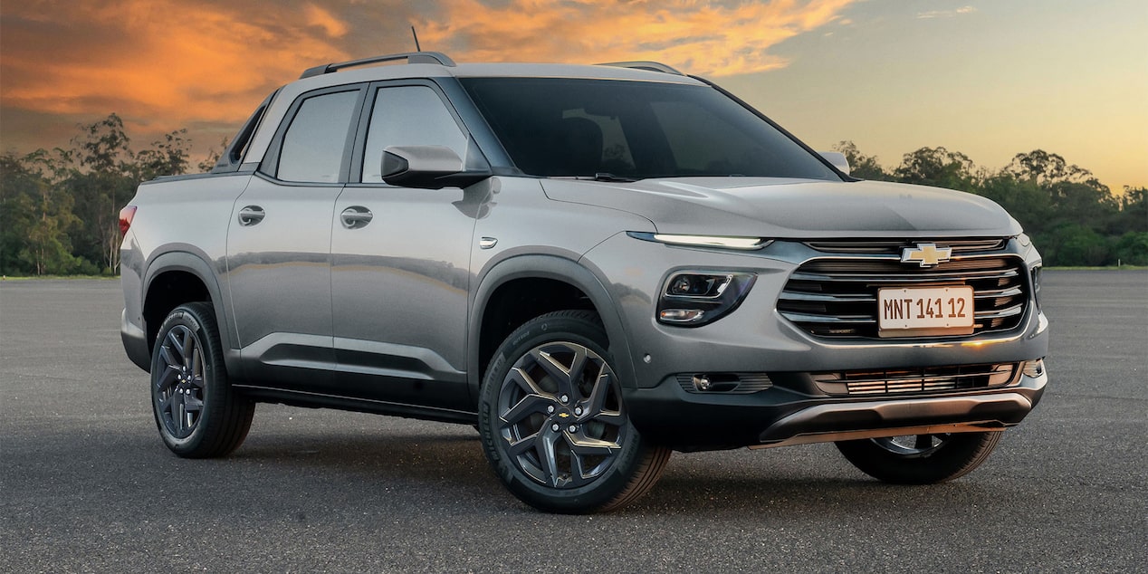 Vista lateral de la Chevrolet Montana estacionada con árboles de fondo.