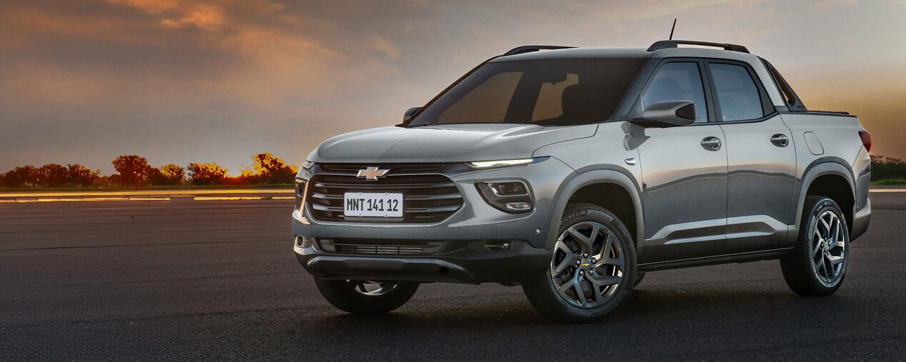 Chevrolet Montana estacionada con vegetación de fondo.