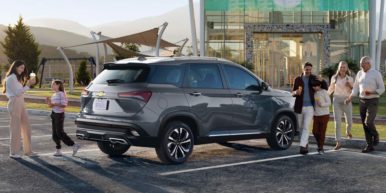 Chevrolet Captiva XL estacionada con una familia rodeándola.